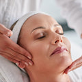 Woman receiving a facial massage at a spa.
