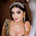 Woman in traditional attire with jewelry and henna, blurred background