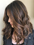 Woman with long, wavy hair in a neutral setting