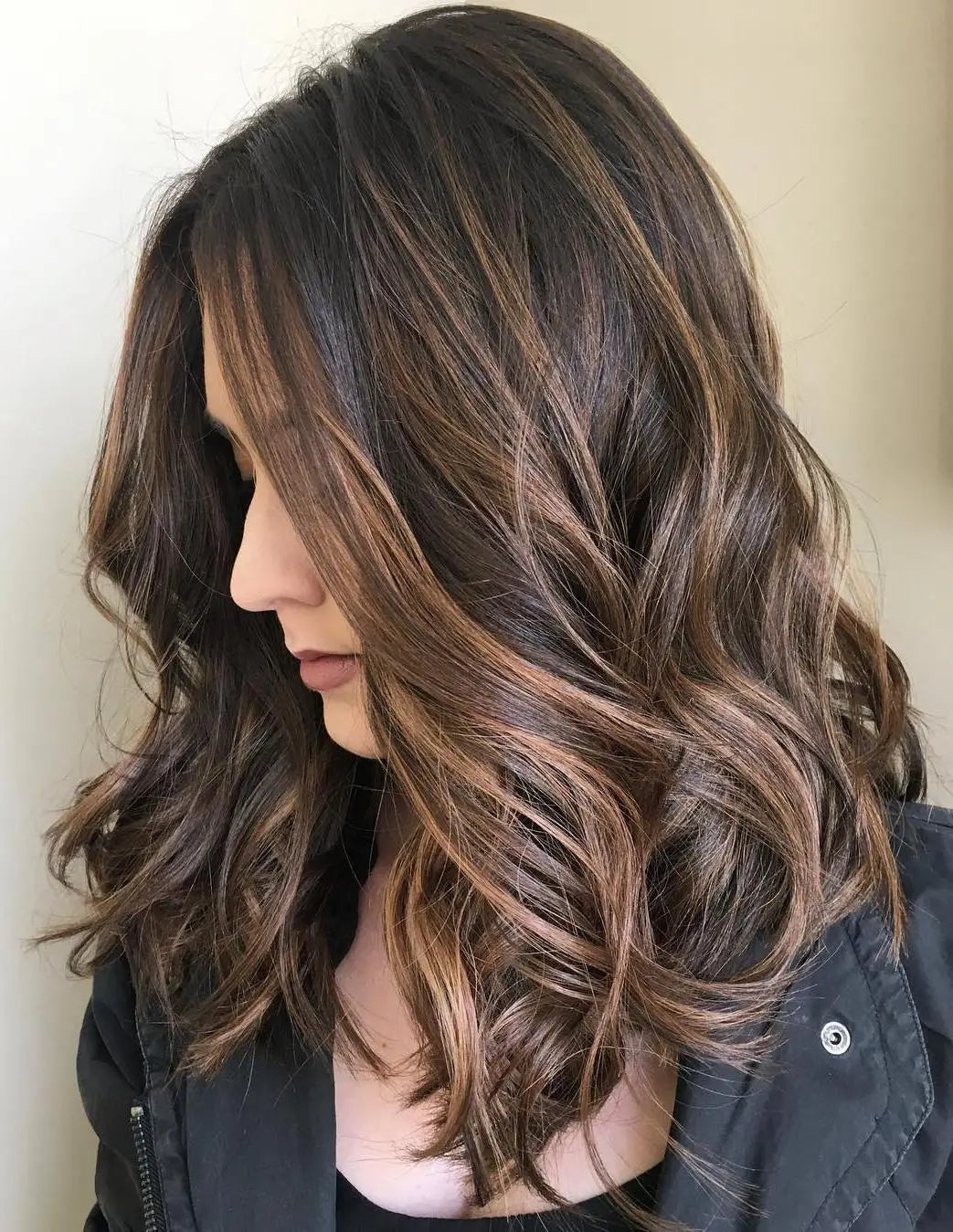 Woman with long, wavy hair in a neutral setting