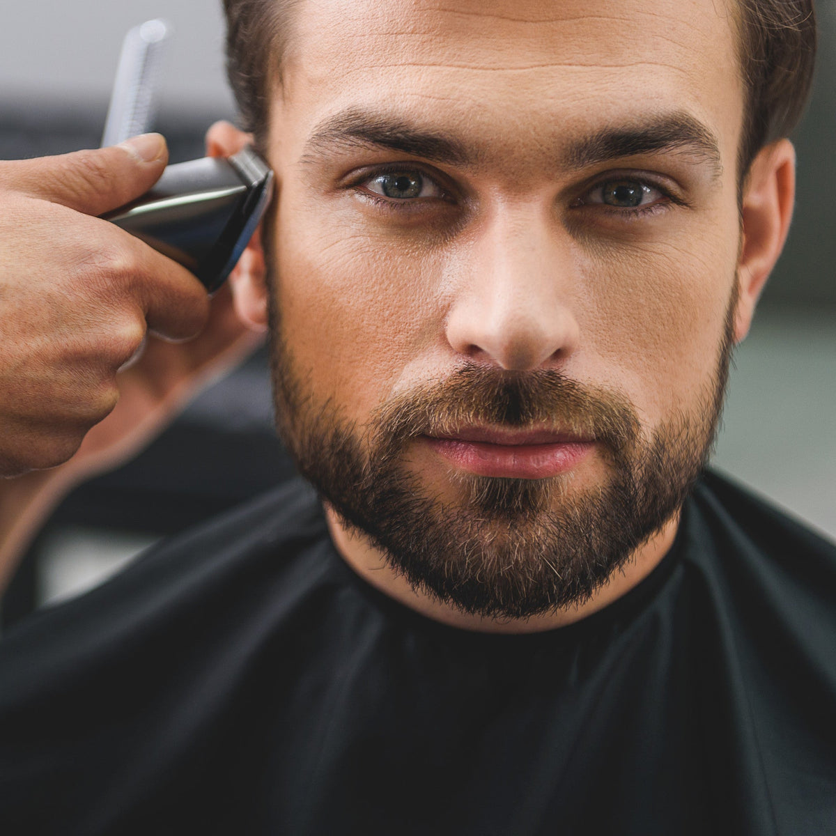 Man getting a haircut with clippers in a barbershop setting