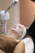 Person receiving a facial treatment with a machine above their head.