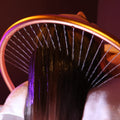 Close-up of a hairbrush with bristles and a purple handle on a blurred background