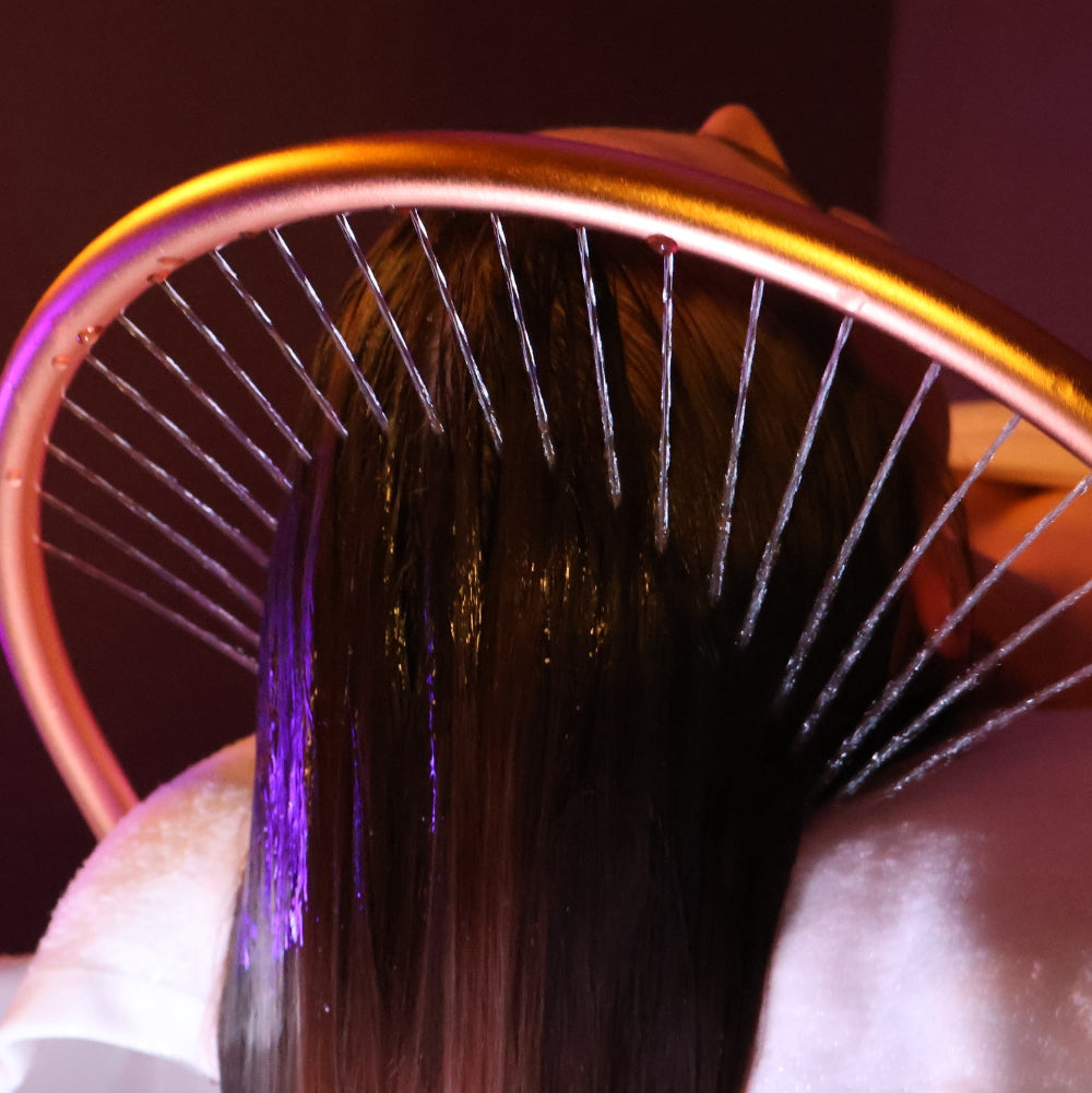 Close-up of a hairbrush with bristles and a purple handle on a blurred background