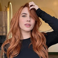 Woman with long, wavy red hair in a salon setting